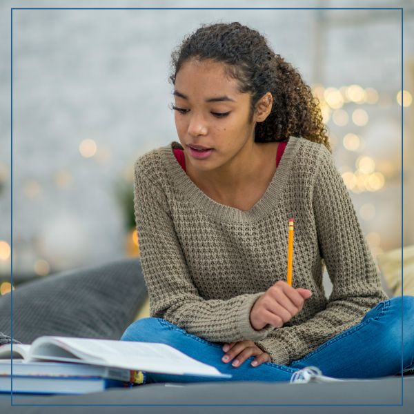 Student making notes while studying political science at Coney University.