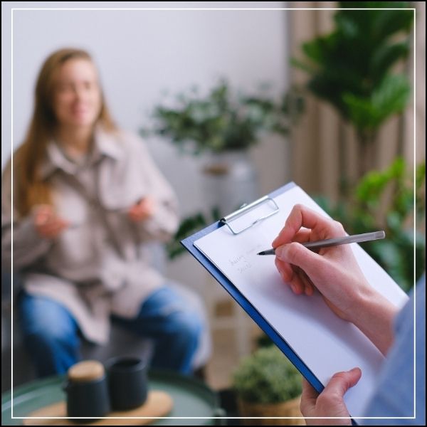 A Psycologist taking notes during therapy with a female patient. A career after studying BA Psychology at Conley University.